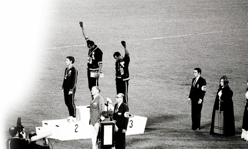 Mexico, 1968: De amerikanske 200-meterløperne Tommie Smith og John Carlos ble utestengt på livstid etter å ha hevet hver sin hånd med et delt svart handskepar på seierspallen, da den svarte borgerrettighetskampen fortsatt pågikk for fullt i USA. Dokumentaren Salute fra 2008, viser hvordan tredjemann på pallen, den australske sølvvinner Peter Norman, også deltok i den politiske gesten. FOTO: NTB SCANPIX Mexico, 1968: De amerikanske 200-meterløperne Tommie Smith og John Carlos ble utestengt på livstid etter å ha hevet hver sin hånd med et delt svart handskepar på seierspallen, da den svarte borgerrettighetskampen fortsatt pågikk for fullt i USA. Dokumentaren Salute fra 2008, viser hvordan tredjemann på pallen, den australske sølvvinner Peter Norman, også deltok i den politiske gesten. FOTO: NTB SCANPIX