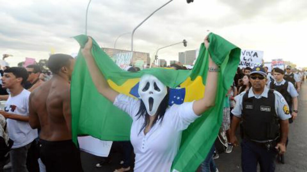 MASKER: Demonstranter i flere byer i Brasil bærer masker som blir symbolisert med folkeopprør flere steder i verden. Her er det studenter i hovedstaden Brasilia i går som roper slagord mot korrupsjon og politikernes favorisering av seg selv. Foto: AFP PHOTO/NTB Scanpix. MASKER: Demonstranter i flere byer i Brasil bærer masker som blir symbolisert med folkeopprør flere steder i verden. Her er det studenter i hovedstaden Brasilia i går som roper slagord mot korrupsjon og politikernes favorisering av seg selv. Foto: AFP PHOTO/NTB Scanpix.