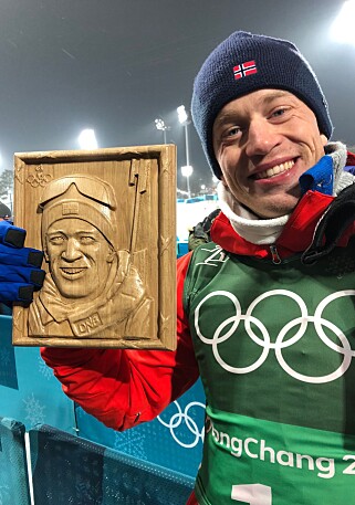 GAVE: Tarjei Bø fikk en gave i målområdet etter stafetten i går; en flott utskåret treplakett av ham. Foto: Roy Wahlstrøm GAVE: Tarjei Bø fikk en gave i målområdet etter stafetten i går; en flott utskåret treplakett av ham. Foto: Roy Wahlstrøm
