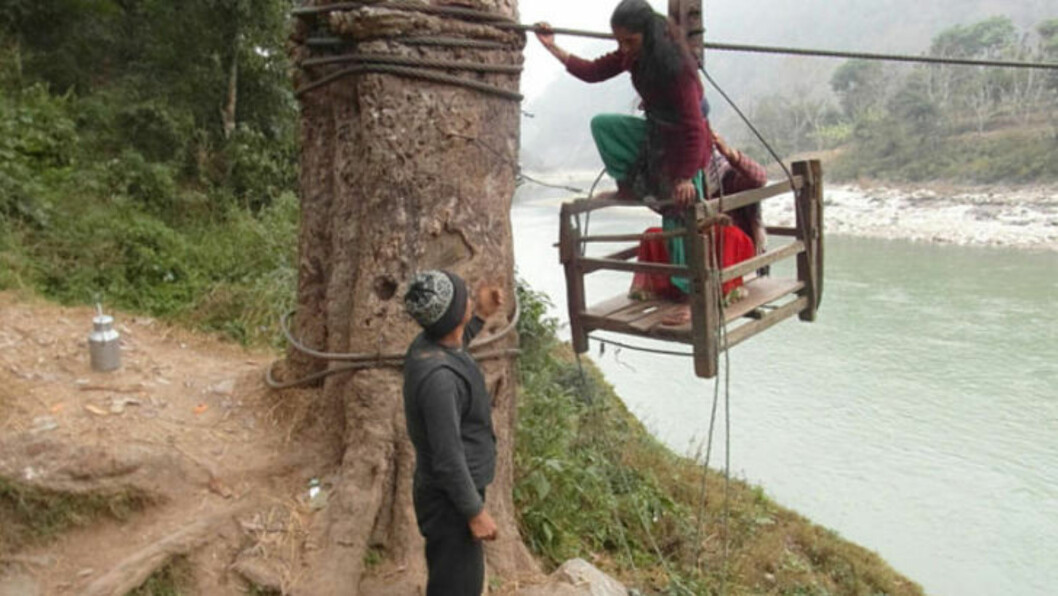 <strong>FÅR HJELP:</strong> To jenter får hjelp til å komme ned etter å ha brukt taubanen. Foto: Manish Duwadi / Barcroft India <strong>FÅR HJELP:</strong> To jenter får hjelp til å komme ned etter å ha brukt taubanen. Foto: Manish Duwadi / Barcroft India