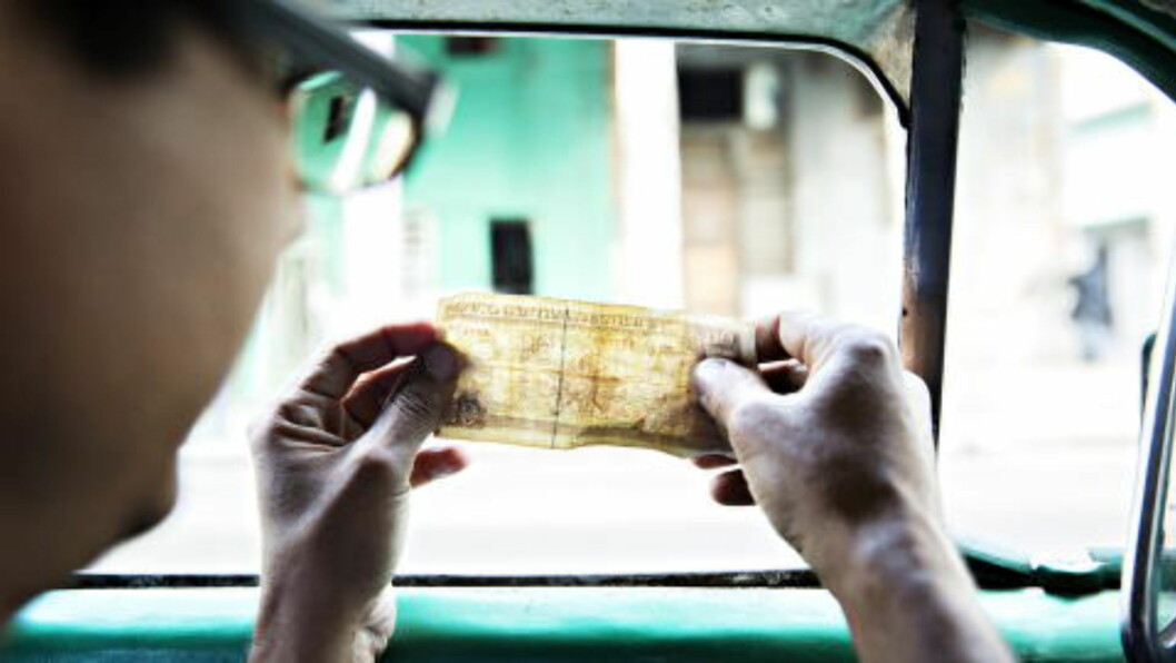 <strong>GODE PENGER:</strong> Hver passasjer betaler 10 pesos cubanos, cirka tre-fire kroner. Det blir en del penger i løpet av en dag. Her sjekker sjåføren at seddelen er ekte. Foto: NINA HANSEN <strong>GODE PENGER:</strong> Hver passasjer betaler 10 pesos cubanos, cirka tre-fire kroner. Det blir en del penger i løpet av en dag. Her sjekker sjåføren at seddelen er ekte. Foto: NINA HANSEN