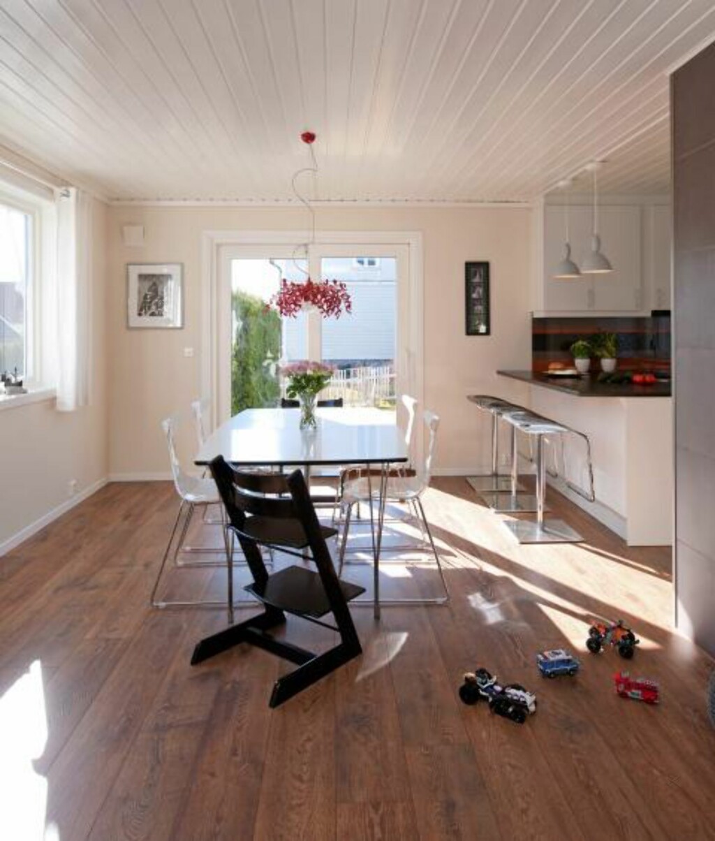 BEVISSTE LINJER: Gulvplankene, i dette tilfellet enstavslaminat fra Pergo, er lagt i rommets lengderetning og bidrar til at blikket dras mot lyset. Spisebord og stoler fra Living. Den røde pendelen SuperLeaves er fra Furtex agenturer, mens pendlene over kjøkkenøya er fra Pur Norsk. Foto: Espen Grønli BEVISSTE LINJER: Gulvplankene, i dette tilfellet enstavslaminat fra Pergo, er lagt i rommets lengderetning og bidrar til at blikket dras mot lyset. Spisebord og stoler fra Living. Den røde pendelen SuperLeaves er fra Furtex agenturer, mens pendlene over kjøkkenøya er fra Pur Norsk. Foto: Espen Grønli