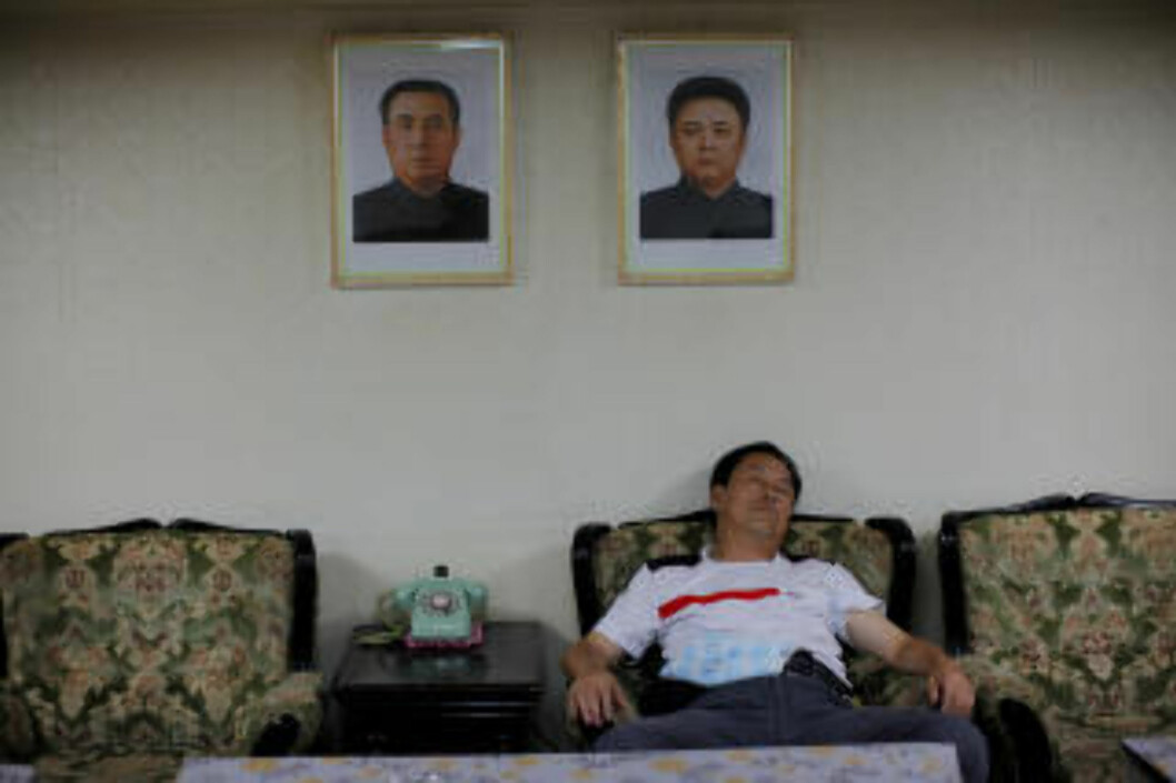 SLAPPER AV: Et medlem av den kinesiske turistdelegasjonen sover under bildene av Nord-Koreas leder Kim Jong-II og hans avdøde far Kim II-Sung. Foto: CARLOS BARRIA/REUTERS/SCANPIX SLAPPER AV: Et medlem av den kinesiske turistdelegasjonen sover under bildene av Nord-Koreas leder Kim Jong-II og hans avdøde far Kim II-Sung. Foto: CARLOS BARRIA/REUTERS/SCANPIX