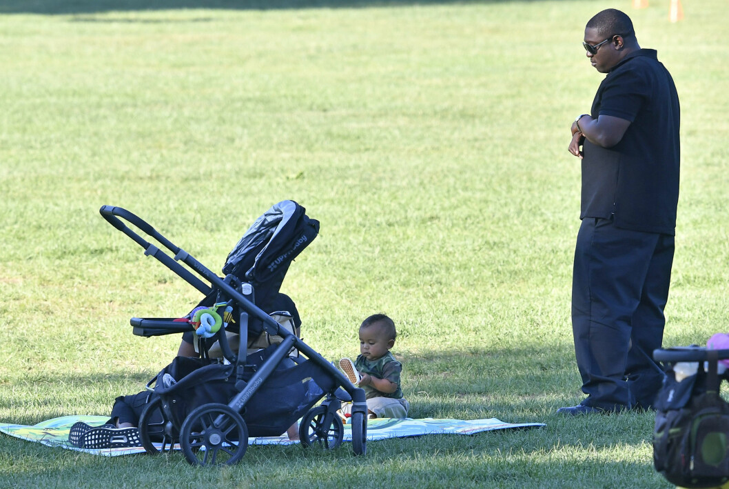 STJERNEBABY: Det var unektelig et litt pussig syn da den mørkkledde livvakten stod rolig og så på Saint West mens han lekte i Central Park. Foto: Splash News STJERNEBABY: Det var unektelig et litt pussig syn da den mørkkledde livvakten stod rolig og så på Saint West mens han lekte i Central Park. Foto: Splash News