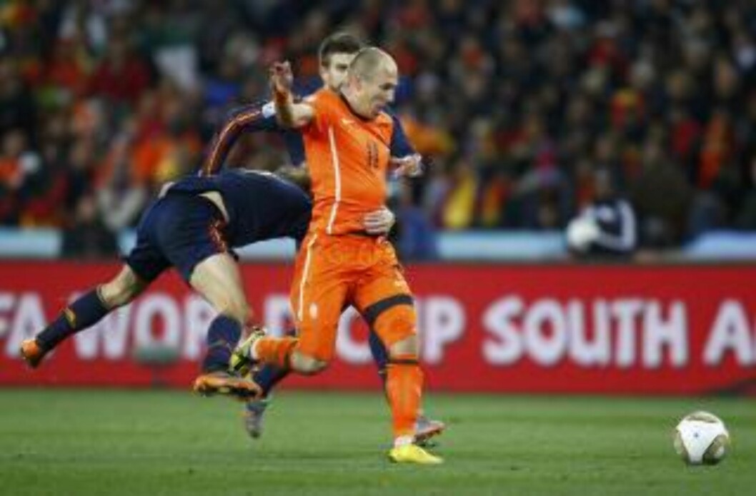 <strong>LIVTAK:</strong> Carlos Puyol festet grepet om midjen på Arjen Robben, men ikke nok til at vingen fikk frispark og Spania rødt kort, mente Webb. Foto: Franck Fife / AFP. <strong>LIVTAK:</strong> Carlos Puyol festet grepet om midjen på Arjen Robben, men ikke nok til at vingen fikk frispark og Spania rødt kort, mente Webb. Foto: Franck Fife / AFP.