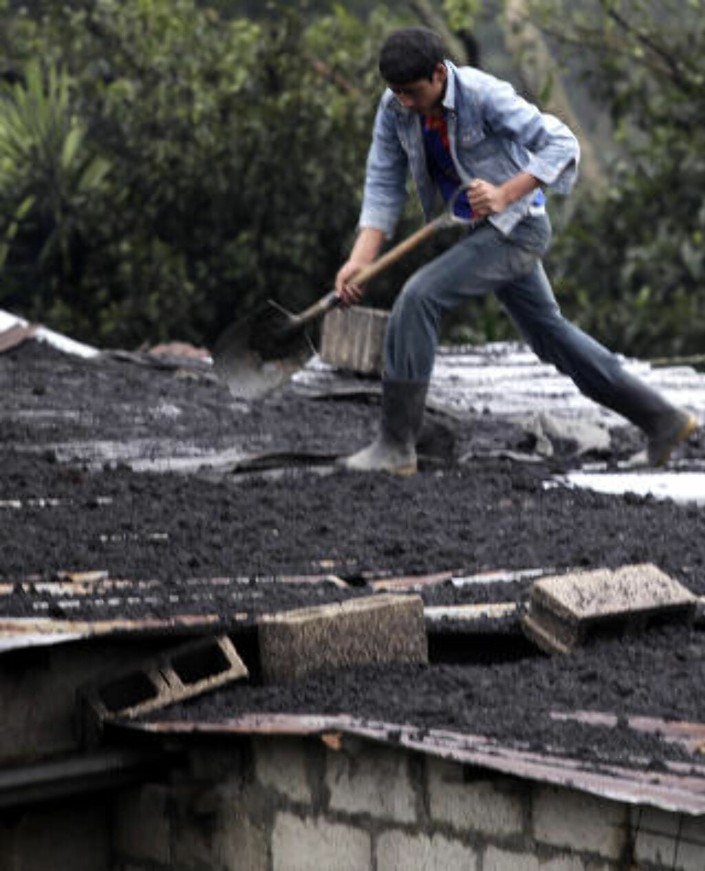 RENGJØR: En mann rengjør taket sitt etter vulkanutbruddet. Foto: Daniel LeClair/REUTERS RENGJØR: En mann rengjør taket sitt etter vulkanutbruddet. Foto: Daniel LeClair/REUTERS