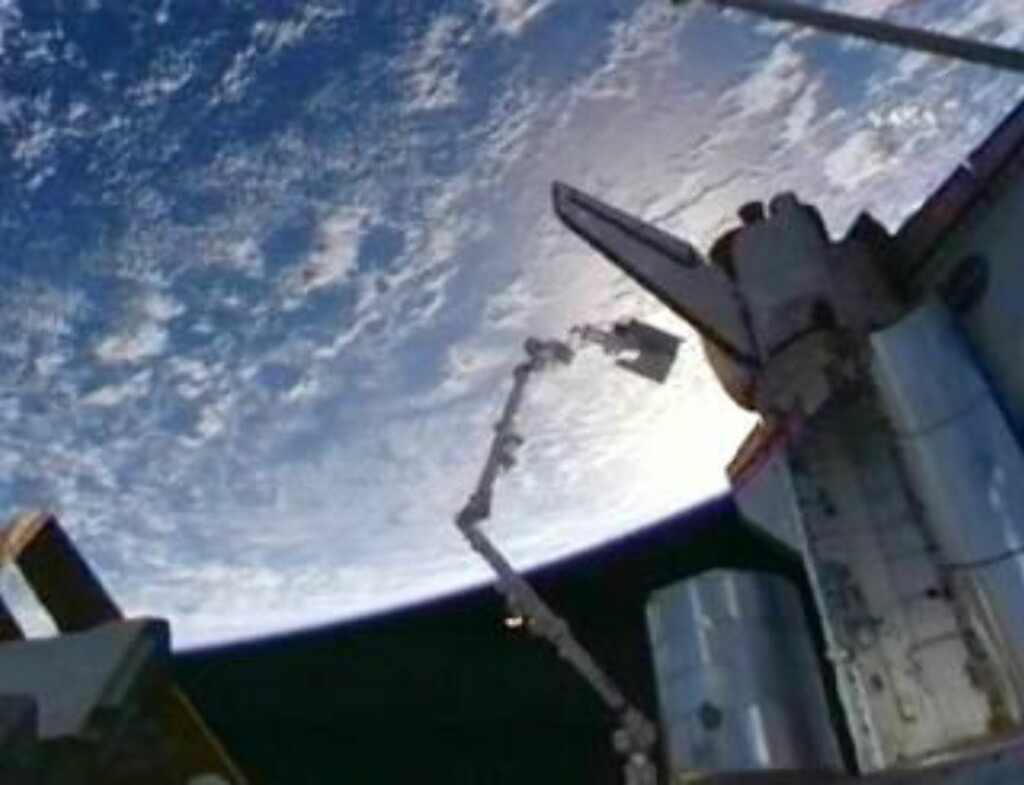 HØYT OPPE: Christer Fuglesang henger i enden av en robotarm som assisterte ham i skiftet av en tom ammoniakktank på ISS. Foto: NASA TV HØYT OPPE: Christer Fuglesang henger i enden av en robotarm som assisterte ham i skiftet av en tom ammoniakktank på ISS. Foto: NASA TV