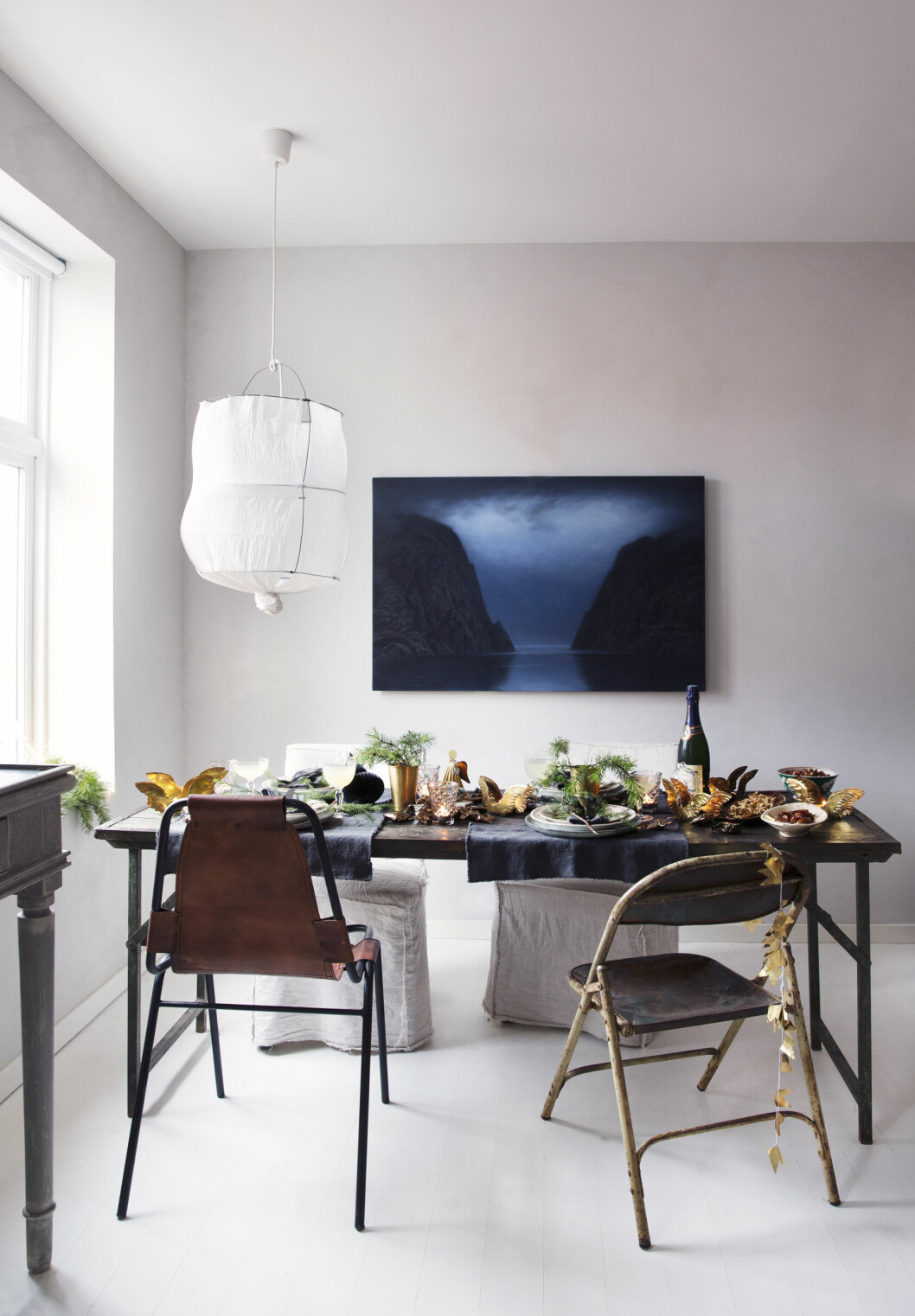 MED GULL OG GRANBAR: Spisebordet fra The travelling band er omgitt av en skinnstol fra Millas boutique, en gammel stålrørsstol Tone har hatt i mange år, og to Ikea-stoler som har fått nytt liv med Tones hjemmesydde trekk. Bordet er pyntet med granbar og gull. Bildet på veggen er av Christoffer Rådlund, lampen er fra Bolina. Foto: Yvonne Wilhelmsen MED GULL OG GRANBAR: Spisebordet fra The travelling band er omgitt av en skinnstol fra Millas boutique, en gammel stålrørsstol Tone har hatt i mange år, og to Ikea-stoler som har fått nytt liv med Tones hjemmesydde trekk. Bordet er pyntet med granbar og gull. Bildet på veggen er av Christoffer Rådlund, lampen er fra Bolina. Foto: Yvonne Wilhelmsen