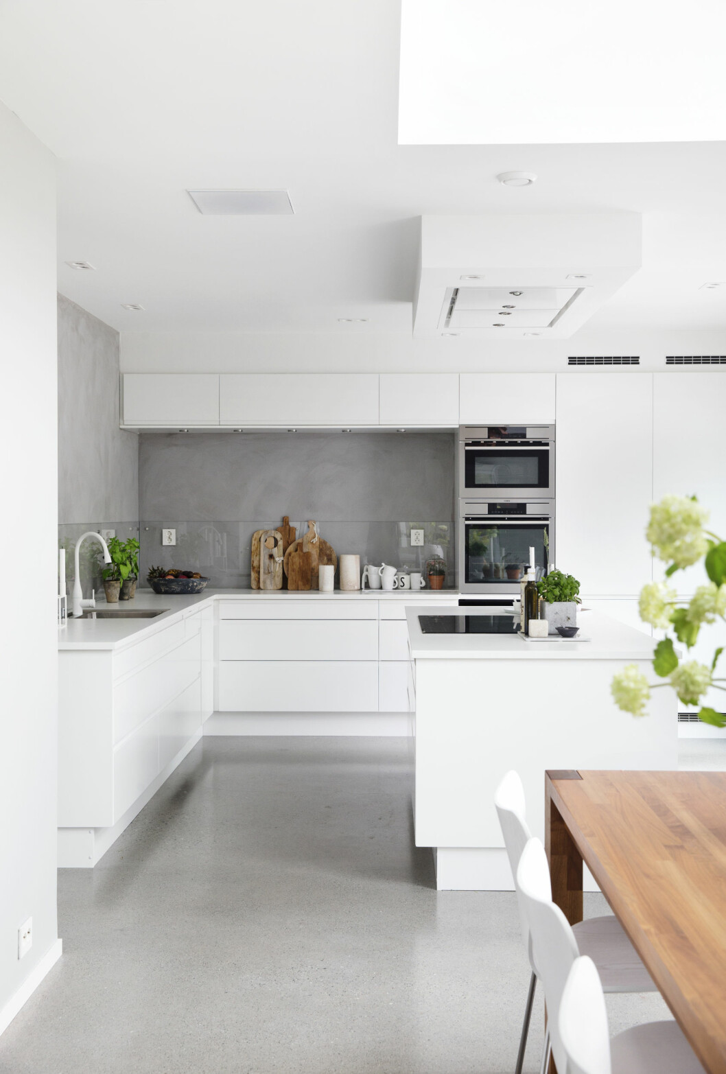 Designikonet fra 1958, PH Konglelampen fra hus & hjem Louis Poulsen, var det første Lena og Stian kjøpte til huset. Over spiseplassen er det åpent gjennom andre etasje helt opp til husets tak. På bordet står en samling krukker og vaser fra Bolina med silkeblomster fra samme sted. Det moderne Sigdalkjøkkenet i hvitt får kontrast fra veggen malt med kalkmaling i fargen Elephant Skin fra Pure & Original. Foto: Yvonne Wilhelmsen Designikonet fra 1958, PH Konglelampen fra hus & hjem Louis Poulsen, var det første Lena og Stian kjøpte til huset. Over spiseplassen er det åpent gjennom andre etasje helt opp til husets tak. På bordet står en samling krukker og vaser fra Bolina med silkeblomster fra samme sted. Det moderne Sigdalkjøkkenet i hvitt får kontrast fra veggen malt med kalkmaling i fargen Elephant Skin fra Pure & Original. Foto: Yvonne Wilhelmsen