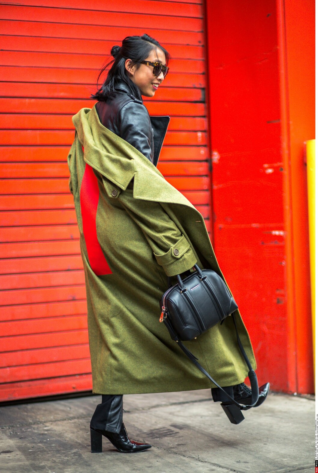Denne fashionistaen bruker en kåpe over bikerjakken sin, og lar kåpen henge ned på den ene skulderen. Foto: All Over Denne fashionistaen bruker en kåpe over bikerjakken sin, og lar kåpen henge ned på den ene skulderen. Foto: All Over