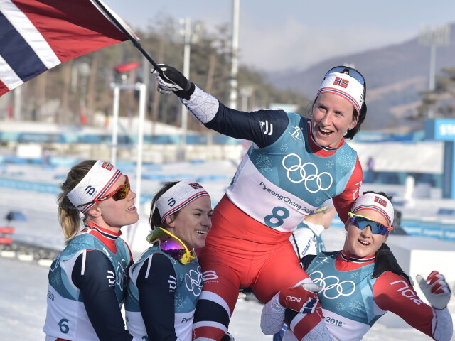 Marit Bjoergen lifted by her teammates after winning gold in South Korea.