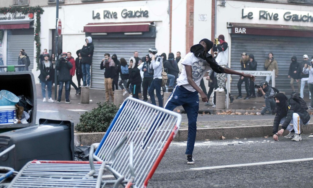 En ung mann kaster en ukjent gjenstand mot politiet i Pont Neuf, i Toulouse, sør i Frankrike, torsdag 6. desember. Foto: Remy Gabalda / AFP En ung mann kaster en ukjent gjenstand mot politiet i Pont Neuf, i Toulouse, sør i Frankrike, torsdag 6. desember. Foto: Remy Gabalda / AFP