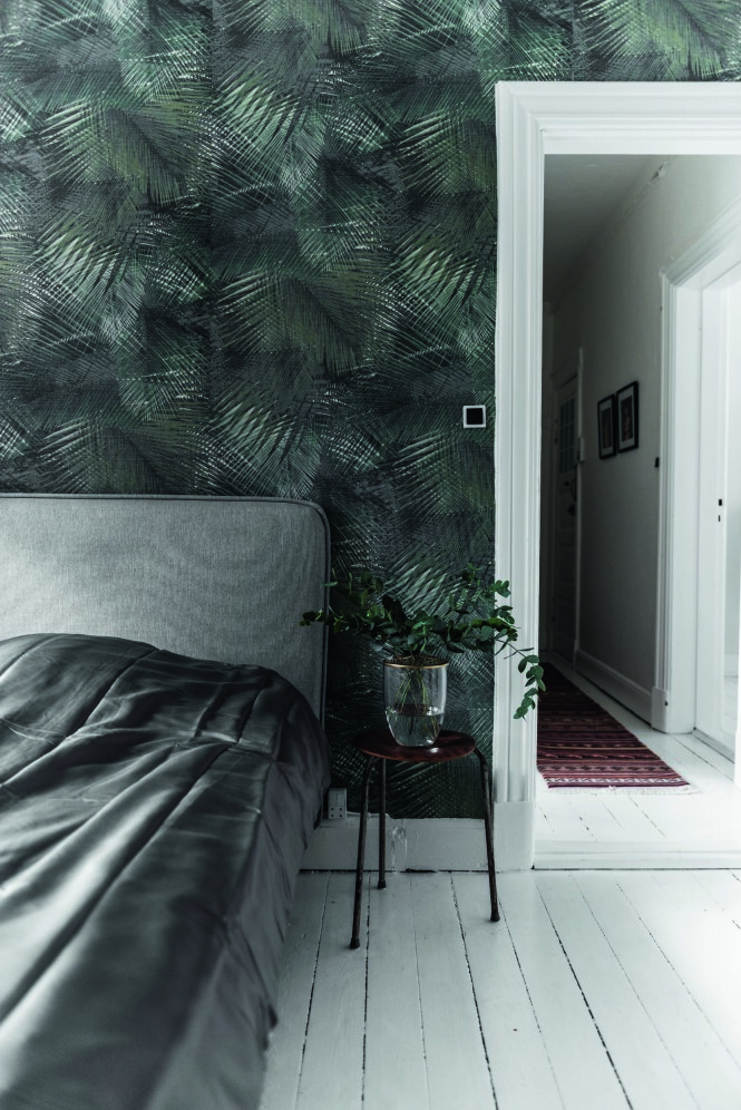 Soverommet har fått støvete farger i nyanser av grønt og grått, kombinert med detaljer i messing. En sengegavl skaper luksuriøs hotellstemning. Palmetapetet er fra Tapetforum, og vasen på bordet er fra Dims Studio. Tips! Skap en avslapningssone på soverommet med få møbler og dempede farger. FOTO: Benjamin Lee Rønning Lassen Soverommet har fått støvete farger i nyanser av grønt og grått, kombinert med detaljer i messing. En sengegavl skaper luksuriøs hotellstemning. Palmetapetet er fra Tapetforum, og vasen på bordet er fra Dims Studio. Tips! Skap en avslapningssone på soverommet med få møbler og dempede farger. FOTO: Benjamin Lee Rønning Lassen