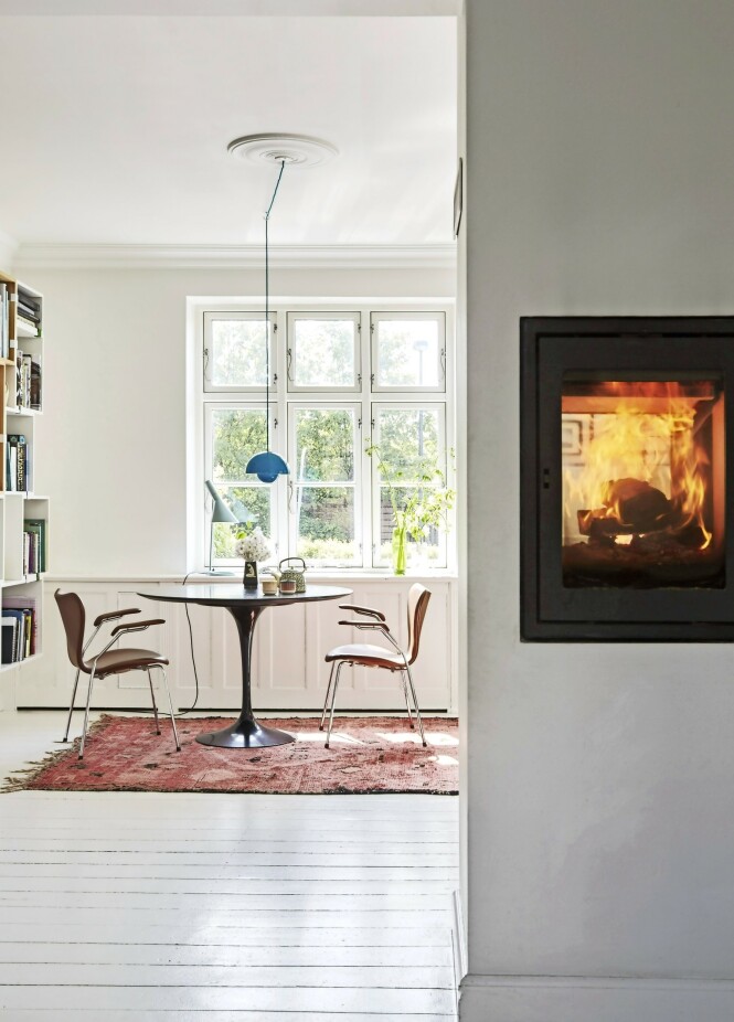 En kikk inn på kjøkkenallrommet. Bordet er designet av Eero Saarinen, stolene av Arne Jacobsen, og «Flowerpot»lampen over bordet av Verner Panton. Tips! En peis som står midt i rommet og som har glass i begge ender, lar lys og flammer spre seg til hele rommet. FOTO: Anitta Behrendt En kikk inn på kjøkkenallrommet. Bordet er designet av Eero Saarinen, stolene av Arne Jacobsen, og «Flowerpot»lampen over bordet av Verner Panton. Tips! En peis som står midt i rommet og som har glass i begge ender, lar lys og flammer spre seg til hele rommet. FOTO: Anitta Behrendt
