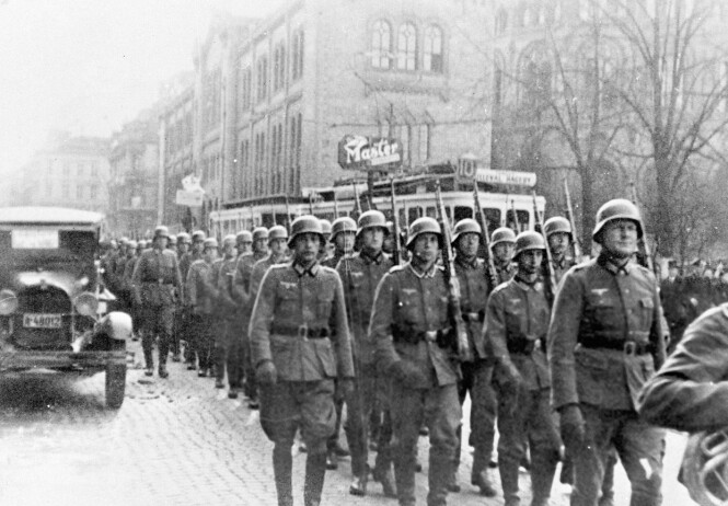 TYSKE TROPPER: Leif fikk streng beskjed av foreldrene om at man ikke står og beundrer fienden som kommer masjerende. Dette bildet er tatt etter den tyske invasjonen av Norge 9. april 1940.
Den tyske troppen marsjerer gjennom Karl Johans gate, med Stortinget i bakgrunnen. FOTO: NTB scanpix TYSKE TROPPER: Leif fikk streng beskjed av foreldrene om at man ikke står og beundrer fienden som kommer masjerende. Dette bildet er tatt etter den tyske invasjonen av Norge 9. april 1940.
Den tyske troppen marsjerer gjennom Karl Johans gate, med Stortinget i bakgrunnen. FOTO: NTB scanpix