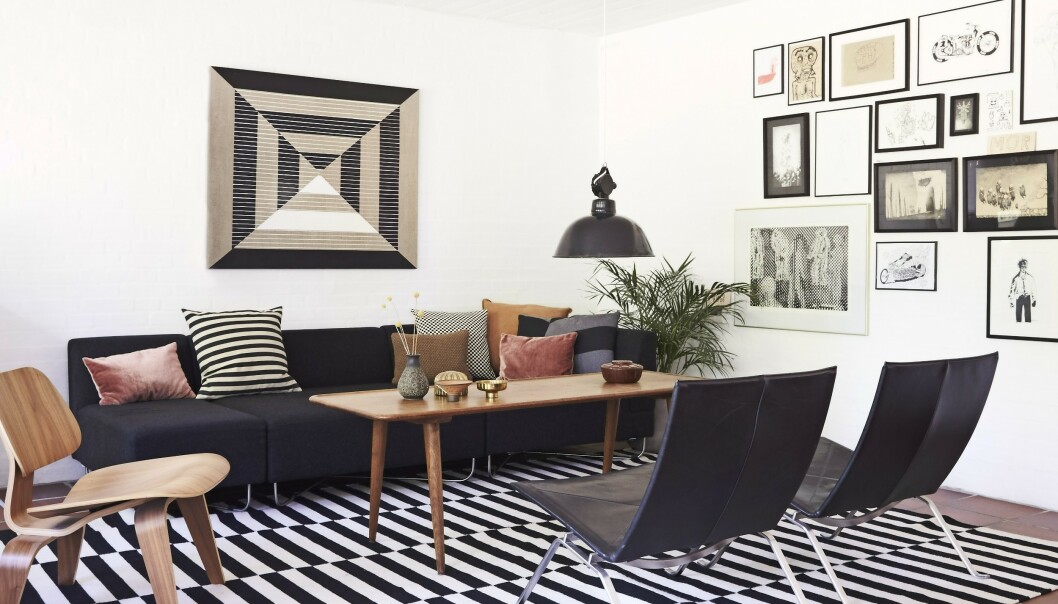 Sofaen fra Bolia.com er fylt med puter fra bl.a. H&M Home, Vintage 415 og Ikea. Wegner-bordet og lampen er vintage, Poul Kjærholmstolene er fra Fritz Hansen, og teppet er fra Ikea. Eames-stolen i valnøttre er fra New York. Over sofaen henger et kunstverk av Anne Aarsland. Tips! Hvis du innreder stramt og grafisk, kan du la veggene fylles med kunstverk. FOTO: Ditte Capion Sofaen fra Bolia.com er fylt med puter fra bl.a. H&M Home, Vintage 415 og Ikea. Wegner-bordet og lampen er vintage, Poul Kjærholmstolene er fra Fritz Hansen, og teppet er fra Ikea. Eames-stolen i valnøttre er fra New York. Over sofaen henger et kunstverk av Anne Aarsland. Tips! Hvis du innreder stramt og grafisk, kan du la veggene fylles med kunstverk. FOTO: Ditte Capion