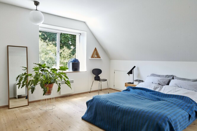 Et blått sengeteppe i ull fra Snorres besteforeldre gir farge til det romslige soverommet. Sengetøy, speil og taklampe er fra Ikea. Mauren-stolen og nattbordet er kjøpt brukt, og bordlampen er fra Louis Poulsen. Kunstverket i vinduskarmen er kjøpt på flidmarked. FOTO: Ditte Capion Et blått sengeteppe i ull fra Snorres besteforeldre gir farge til det romslige soverommet. Sengetøy, speil og taklampe er fra Ikea. Mauren-stolen og nattbordet er kjøpt brukt, og bordlampen er fra Louis Poulsen. Kunstverket i vinduskarmen er kjøpt på flidmarked. FOTO: Ditte Capion