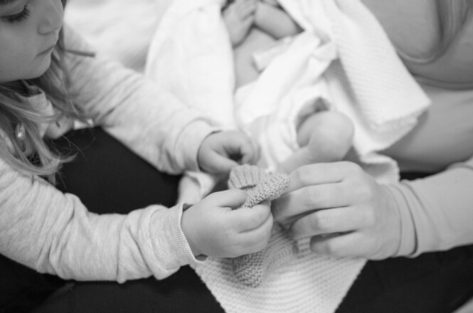 FIN STUND: Storesøster hjelper mamma med å kle på Thelma. Det er farmor som har strikket sokkene, som skulle vært en fødselsgave. Kine og Steffens datter døde i mors liv. FOTO: Trine Lise Henriksen FIN STUND: Storesøster hjelper mamma med å kle på Thelma. Det er farmor som har strikket sokkene, som skulle vært en fødselsgave. Kine og Steffens datter døde i mors liv. FOTO: Trine Lise Henriksen