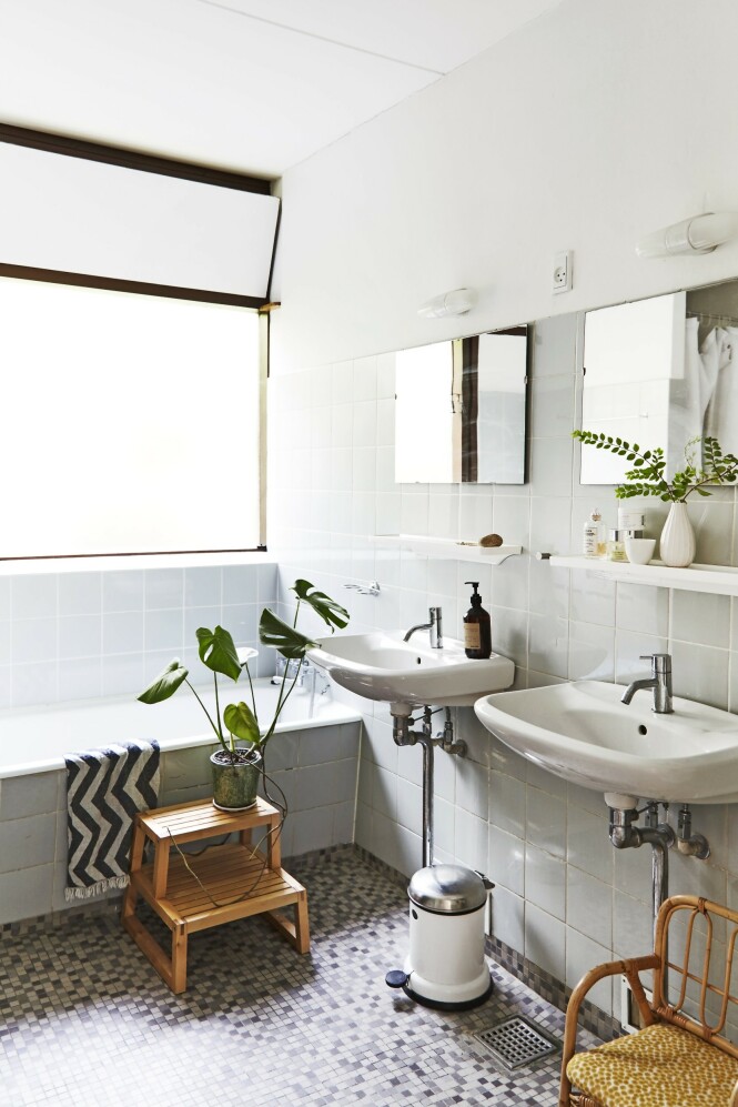 Badet er originalt og fungerer perfekt. En grønn plante og småmøbler i tre gir varme til de hvite vaskene, de sart lyseblå flisene og mosaikkgulvet. FOTO: Nicoline Olsen Badet er originalt og fungerer perfekt. En grønn plante og småmøbler i tre gir varme til de hvite vaskene, de sart lyseblå flisene og mosaikkgulvet. FOTO: Nicoline Olsen