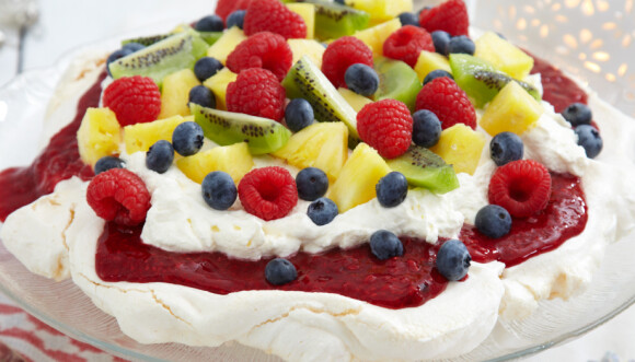 Her er marengsbunnen toppet med rørte bringebær, pisket krem og pyntet med blåbær, bringebær, kiwi og ananas. Foto: Synøve Dreyer Her er marengsbunnen toppet med rørte bringebær, pisket krem og pyntet med blåbær, bringebær, kiwi og ananas. Foto: Synøve Dreyer