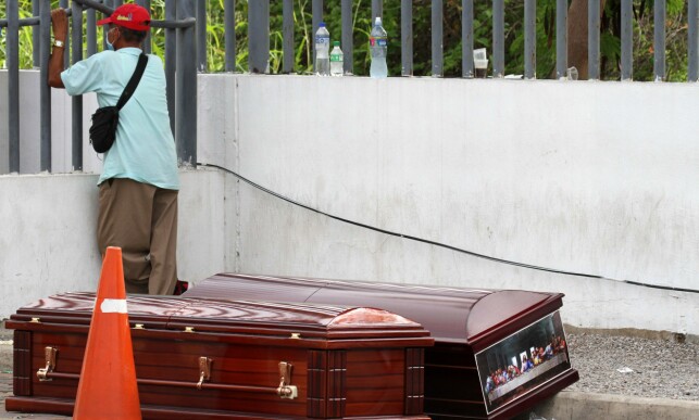 OUTSIDE THE HOSPITAL: A man cares for deceased family members. Photo: Enrique Ortiz / AFP 