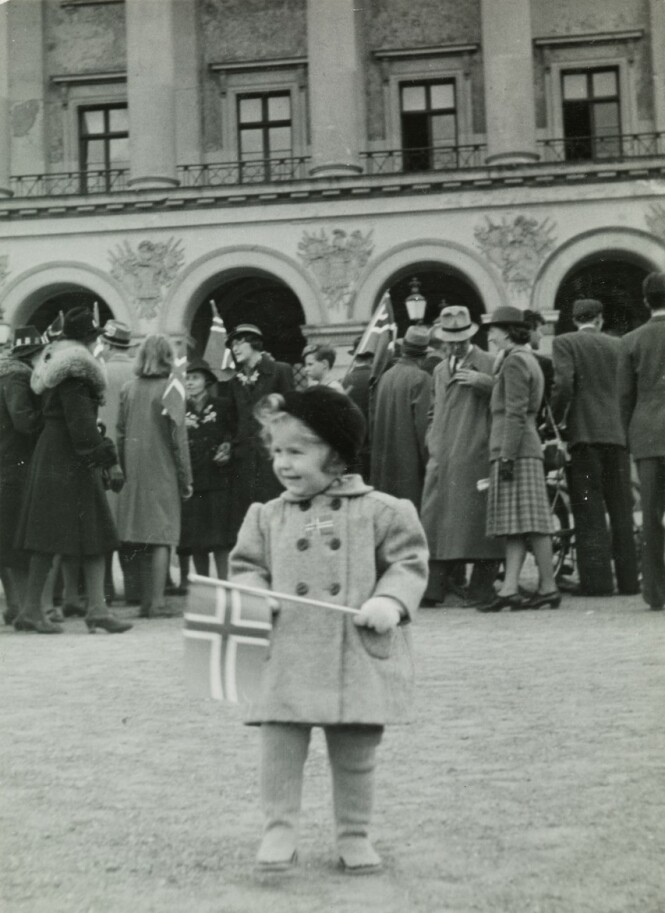LITEN PIKE, STOR DAG: Lille Anne Margrete Holst fotografert foran slottet 17. mai 1945, i påvente av at kronprinsen skulle komme ut og vinke til folket. FOTO: Kjell Johan Saugstad / Oslo Museum LITEN PIKE, STOR DAG: Lille Anne Margrete Holst fotografert foran slottet 17. mai 1945, i påvente av at kronprinsen skulle komme ut og vinke til folket. FOTO: Kjell Johan Saugstad / Oslo Museum