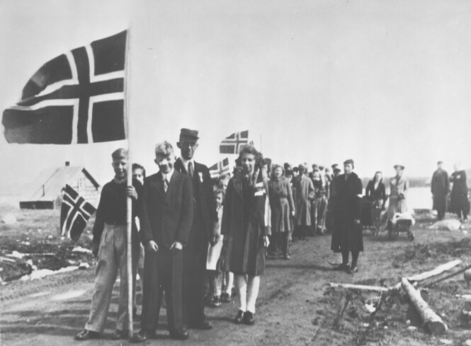 FEIRING: På gården Fjell, tilhørende Emma og Ole Mortensen, drev lærer Trygve Laudal skolen i Sagstua i Sør-Varanger. Her har han og elevene, samt foreldre, samlet seg for 17. mai-tog i 1945. FOTO: Finnmark Fylkesbibliotek / Digitalmuseet FEIRING: På gården Fjell, tilhørende Emma og Ole Mortensen, drev lærer Trygve Laudal skolen i Sagstua i Sør-Varanger. Her har han og elevene, samt foreldre, samlet seg for 17. mai-tog i 1945. FOTO: Finnmark Fylkesbibliotek / Digitalmuseet
