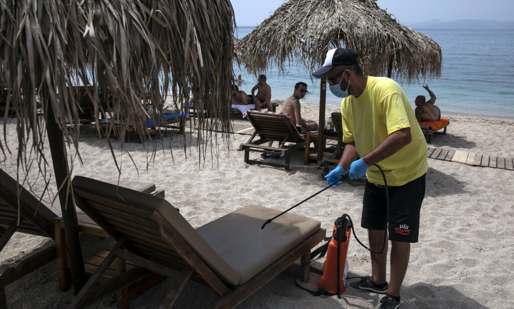 En ansatte desinfiserer en solseng for å gjøre den klar for neste badegjest på Alimos-stranda utenfor Aten lørdag. Foto: Yorgos Karahalis / AP / NTB scanpix En ansatte desinfiserer en solseng for å gjøre den klar for neste badegjest på Alimos-stranda utenfor Aten lørdag. Foto: Yorgos Karahalis / AP / NTB scanpix