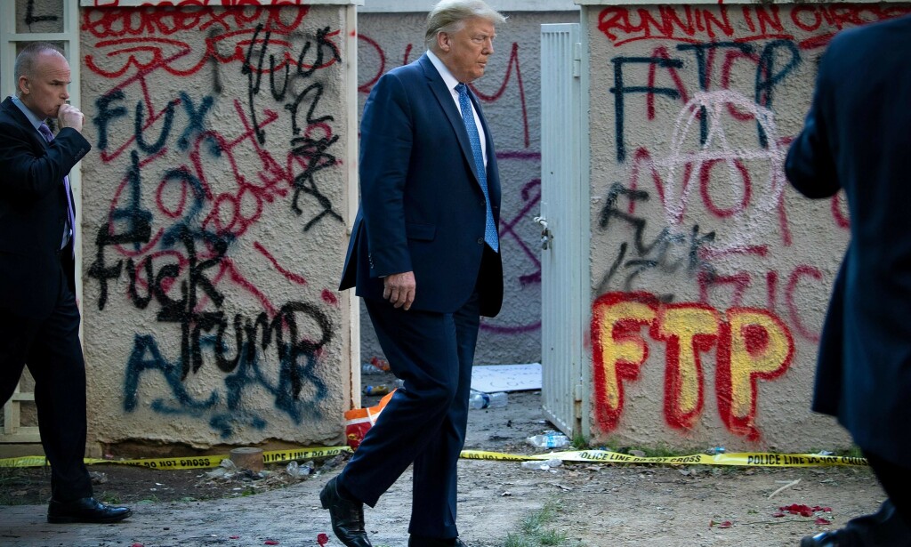 KONTRAST: USAs president på vei tilbake til Det hvite hus etter besøket ved St. John's Church. Bak ham gir graffitien tydelig uttrykk for misnøyen i landet: «Fuck Trump», «ACAB» («alle politifolk er drittsekker») og «FTP» («Fuck the police»). Foto: Brendan Smialowski / AFP / NTB scanpix KONTRAST: USAs president på vei tilbake til Det hvite hus etter besøket ved St. John's Church. Bak ham gir graffitien tydelig uttrykk for misnøyen i landet: «Fuck Trump», «ACAB» («alle politifolk er drittsekker») og «FTP» («Fuck the police»). Foto: Brendan Smialowski / AFP / NTB scanpix