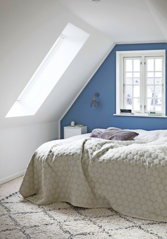Kathrine synes at blåfargen gir en rolig stemning, og hun har derfor malt endeveggen på soverommet blå. Lampen er fra Bestlite og sengeteppet fra Hay. Tips! En vegg malt i en annen farge enn resten av rommet gir ofte en spennende effekt. FOTO: Kira Brandt Kathrine synes at blåfargen gir en rolig stemning, og hun har derfor malt endeveggen på soverommet blå. Lampen er fra Bestlite og sengeteppet fra Hay. Tips! En vegg malt i en annen farge enn resten av rommet gir ofte en spennende effekt. FOTO: Kira Brandt