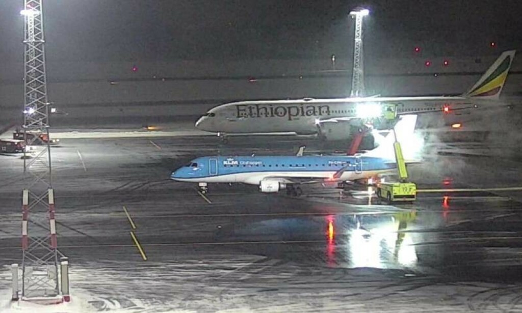 KOLLISJONSØYEBLIKKET: Bildet fra et overvåkingskamera er tatt idet ET-AUP krasjet med masta. Foran et fly som ER dimensjonert for avisingsplassen - et KLM Embraer 190. Foto: Avinor KOLLISJONSØYEBLIKKET: Bildet fra et overvåkingskamera er tatt idet ET-AUP krasjet med masta. Foran et fly som ER dimensjonert for avisingsplassen - et KLM Embraer 190. Foto: Avinor