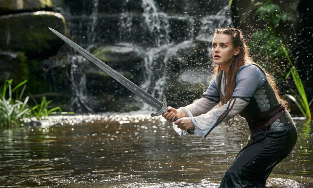 FEILCASTET: Anmelderne lar seg ikke overbevise av sverdsvingingen til Katherine Langford i «Cursed». Foto: Netflix. FEILCASTET: Anmelderne lar seg ikke overbevise av sverdsvingingen til Katherine Langford i «Cursed». Foto: Netflix.