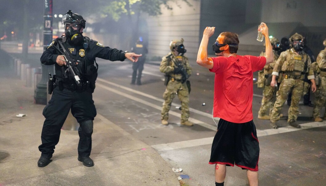 DEMONSTRASJONER: Føderale agenter og en demonstrant i Portland. Foto: Nathan Howard/Getty Images/AFP DEMONSTRASJONER: Føderale agenter og en demonstrant i Portland. Foto: Nathan Howard/Getty Images/AFP